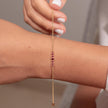 Gold-plated sterling silver zircon bracelet with pink stones worn on wrist