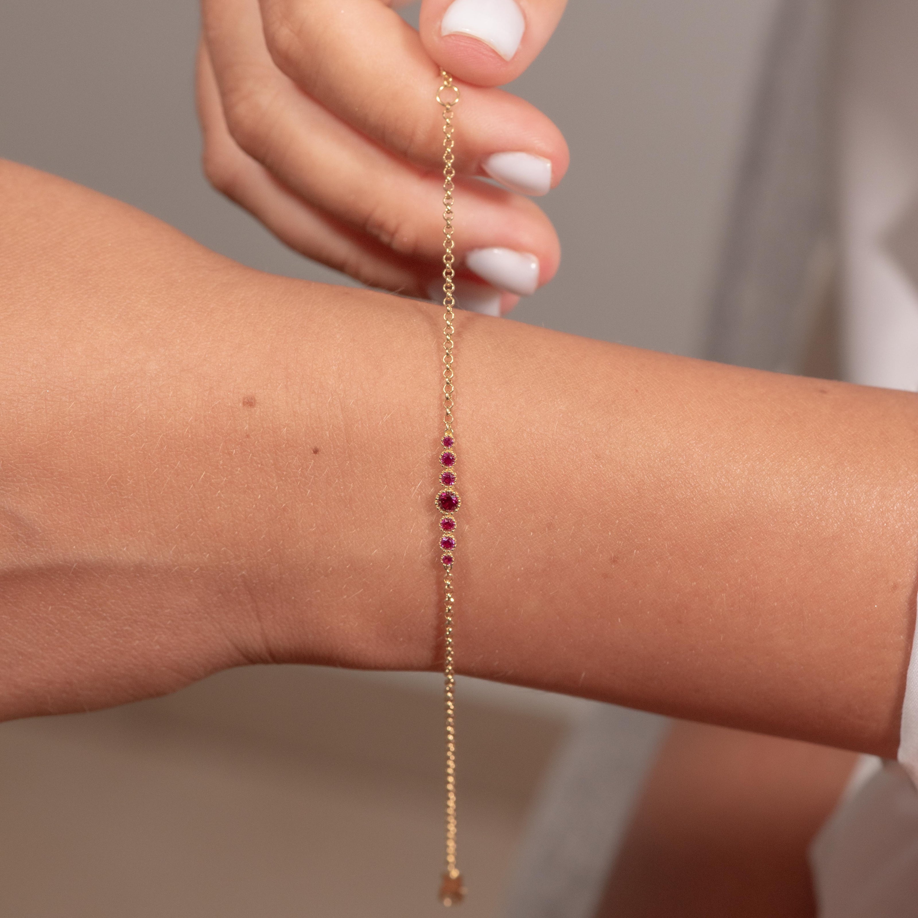 Gold-plated sterling silver zircon bracelet with pink stones worn on wrist