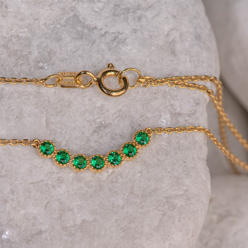 Gold-plated 925 sterling silver chain necklace with central motif of seven green zircon stones in linear arrangement