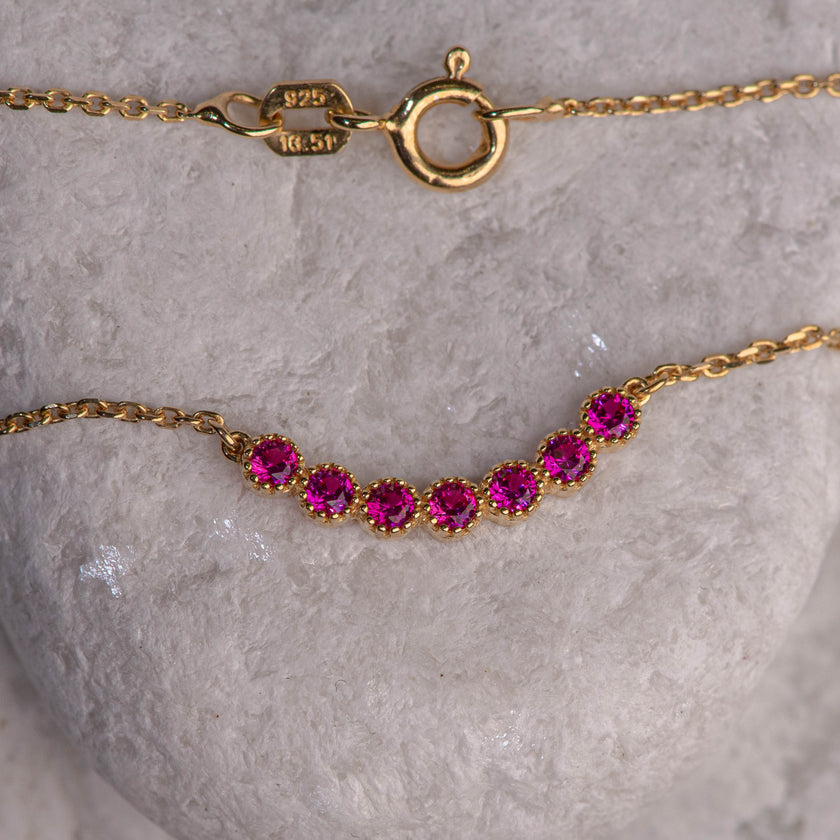 Gold-plated 925 sterling silver chain necklace with central motif of seven pink zircon stones in a modern line