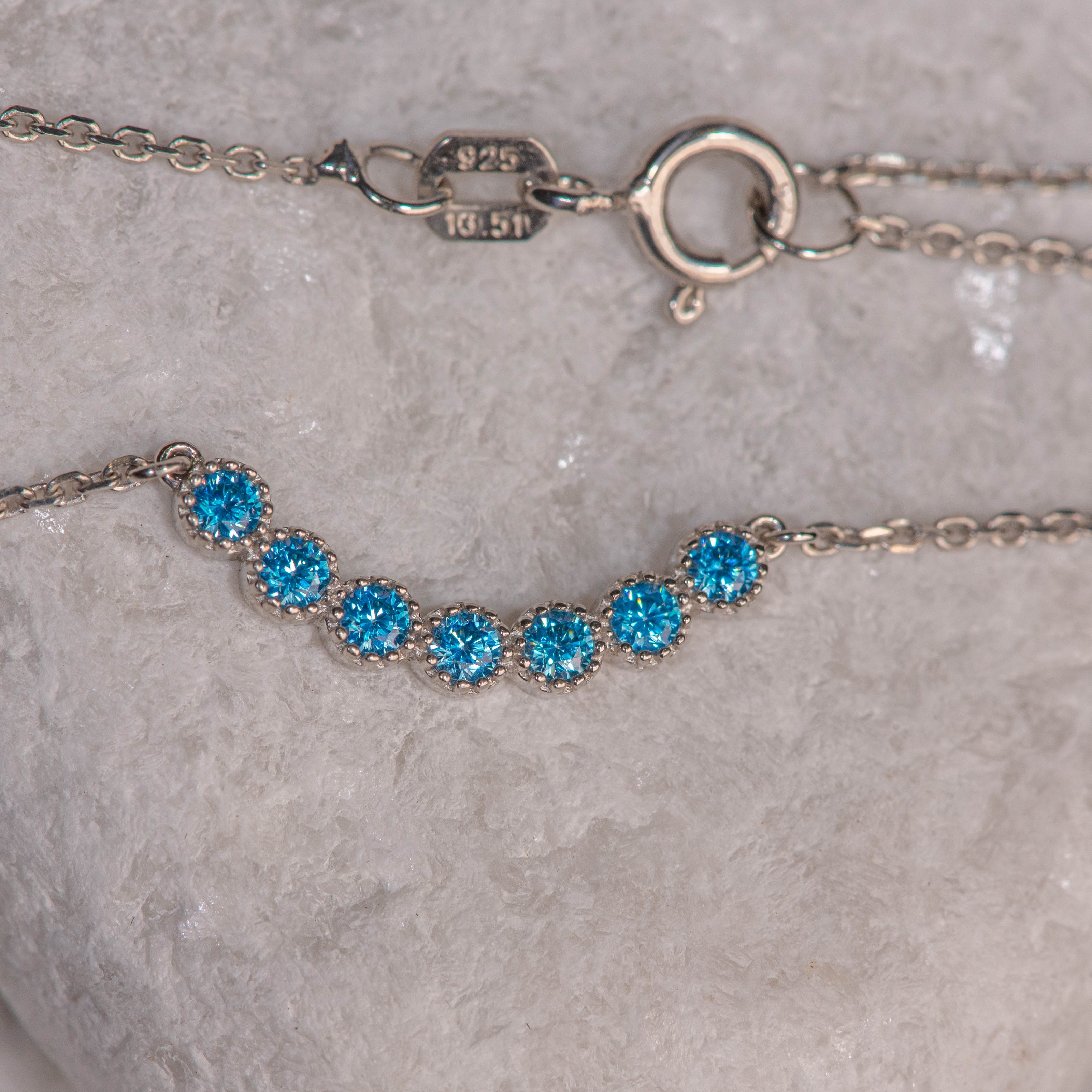 925 sterling silver chain necklace with central motif of seven blue zircon stones in geometric line
